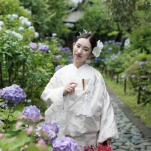 鎌倉 和装 O様・S様2026.06.26 鎌倉・檑亭の石畳で、白無垢姿の花嫁が紫や青の紫陽花に囲まれ、赤紫のブーケを持って微笑む6月の和装前撮り