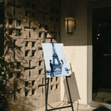 パリ 洋装 I様・I様 2025.09.17 結婚式会場の入口に設置されたイーゼルに、エッフェル塔で撮影したパリ前撮りを飾ったウェルカムボード