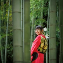 成人式撮影 S様 2022.12.03 建長寺の竹林で、金色の帯結びを見せながら振り返って微笑む、赤い振袖姿の女性