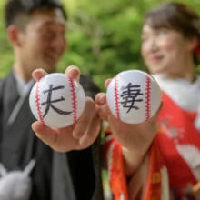 鎌倉 和装 M様・H様 2021.06.02 「夫」と「妻」の文字を書いた二つの野球ボールを、新郎新婦がカメラへ向けて差し出す鎌倉和装前撮り
