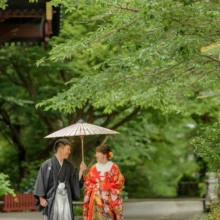 鎌倉 和装 M様・H様 2021.06.02 妙本寺の新緑に包まれた境内を、白い和傘に入り並んで歩く色打掛の新婦と黒紋付袴の新郎
