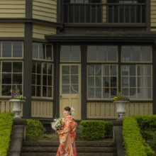 横浜 和装 Y様・O様 2022.04.14 山手イタリア山庭園の西洋館前の階段で、赤を基調とした色打掛の裾を広げて立つ新婦の全身