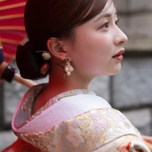 馬車道で色打掛の美しい柄とヘアメイクを印象的に残した、花嫁の和装ウェディングフォト|縁グラフィの姉妹ブランドLuca 横浜・馬車道で赤い和傘を背景に、華やかな色打掛をまとった花嫁の横顔
