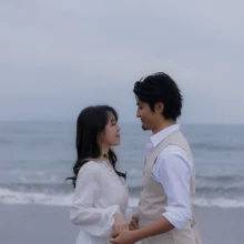由比ヶ浜の海辺で見つめ合う、ふたりの自然な表情を残したウェディングフォト|縁グラフィの姉妹ブランドLuca 由比ヶ浜の海を背景に、向かい合って見つめ合うウェディング姿の新郎新婦