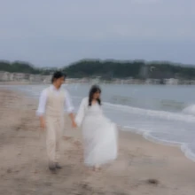由比ヶ浜の波打ち際を歩くふたりを、スローシャッターで印象的に残したウェディングフォト|縁グラフィの姉妹ブランドLuca 由比ヶ浜の波打ち際を手をつないで歩く新郎新婦を、スローシャッターで幻想的に捉えたウェディングフォト