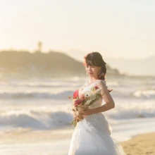 鎌倉・七里ガ浜で冬に撮影した洋装前撮り 鎌倉・七里ガ浜でウェディングドレスを着用した新婦がブーケを持って写る洋装ソロショット