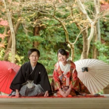 鎌倉和洋装S様・S様 2019.12.23 鎌倉の寺院で赤い敷物に正座し、紅白の和傘を両側に添えた黒紋付袴の新郎と色打掛の新婦