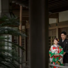 鎌倉 和装 T様・U様 2020.09.29 光明寺の回廊で、緑と赤を基調とした色打掛の新婦と黒紋付袴の新郎が寄り添う鎌倉和装前撮り