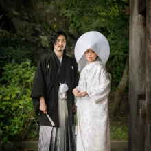 鎌倉 和装 M様・M様 2020.09.18 緑に囲まれた鎌倉の寺院で、綿帽子と白無垢の新婦が黒紋付袴の新郎と並ぶ全身姿