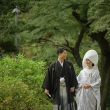 鎌倉 和装 N様N様 2020.11.02 妙本寺の緑に囲まれた小径で、綿帽子と白無垢姿の新婦と黒紋付袴姿の新郎が手をつなぎ、見つめ合いながら歩く