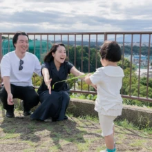 家族写真 M様 2025.09.21 公園の展望台で待つ両親に向かって駆け寄る幼い子どもと、笑顔で迎える家族の様子