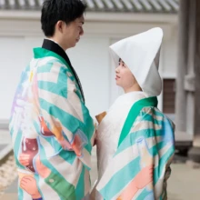 鎌倉 和装 S様・B様 2026.04.01 建長寺の境内で、白無垢と黒紋付袴の上に同じ柄のよさこい衣装を羽織り、向かい合って微笑む新郎新婦