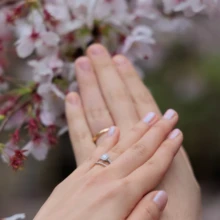 鎌倉 和装 M様・I様 2026.04.02 満開の桜の前で、淡い色のネイルと結婚指輪を着けた新婦が両手を重ねた鎌倉和装前撮りの手元カット