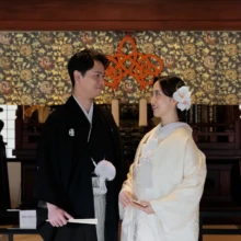 鎌倉 和装 T様・K様 2026.04.05 円覚寺の装飾豊かな堂内で、黒紋付袴の新郎と白無垢の新婦が向かい合って微笑む上半身のカット