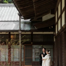鎌倉 和装 T様・K様 2026.04.05 円覚寺の回廊の奥で、黒紋付袴の新郎の腕に白無垢の新婦が手を添えて寄り添う縦構図の和装前撮り