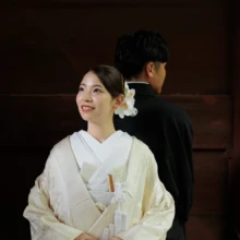 鎌倉 和装 I様・Y様 2026.07.05 妙本寺の山門を背景に、背中合わせで立つ黒紋付袴の新郎と白無垢姿で空を見上げる新婦